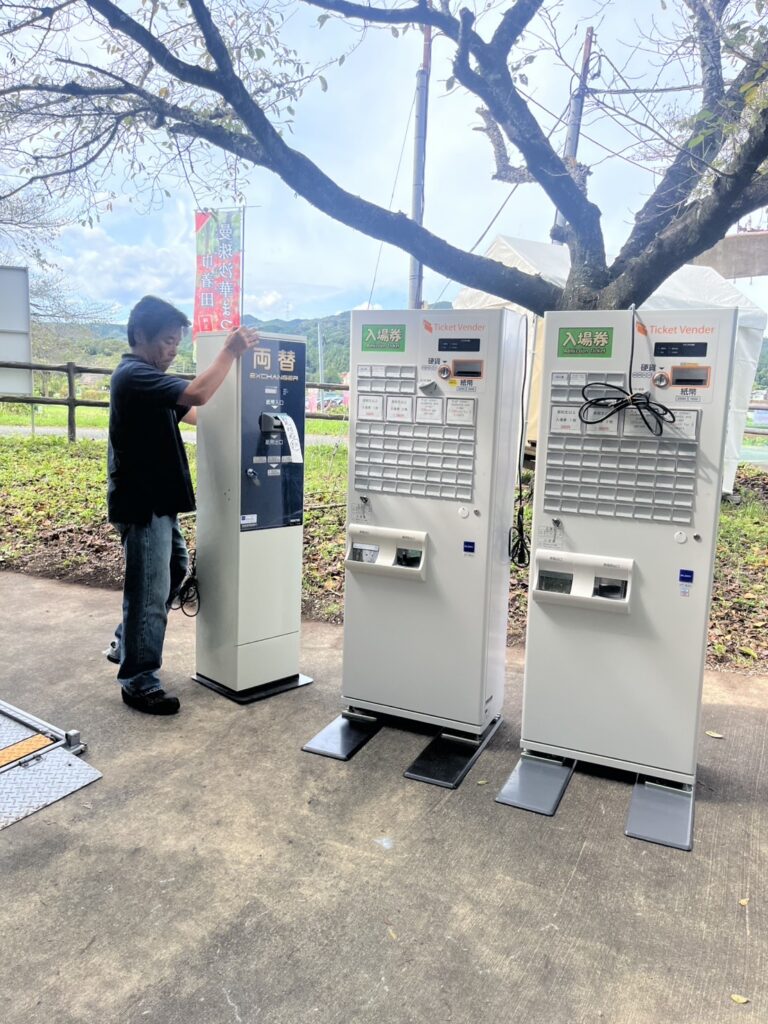 レンタル券売機をイベント会場へ設置するアトラスのスタッフ テントがあれば屋外使用が可能
