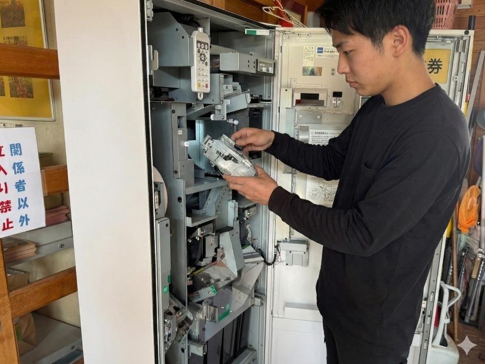 券売機のメニュー登録とコインメックを交換するアトラスのスタッフ