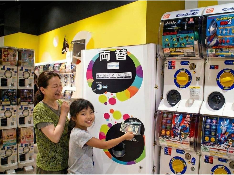 ガチャガチャ前で両替する少女と祖母