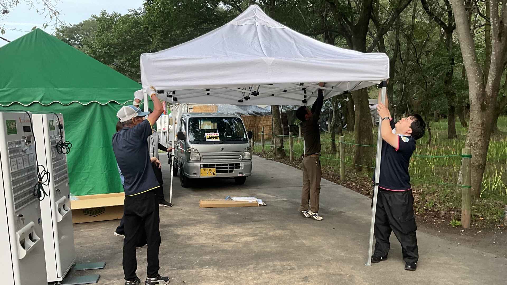 日高市の曼珠沙華まつりでワンタッチテントを準備する日高市職員とアトラスのスタッフ