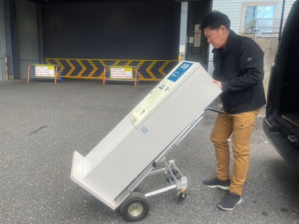 TBS「いくらかわかる金ね?」の番組で使う両替機を運ぶアトラススタッフの亀山くん