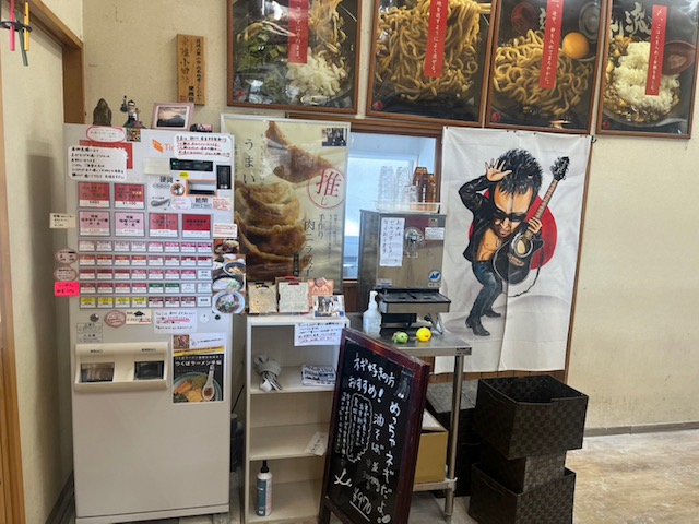 茨城県つくば市「らーめん逆流」様の店内 券売機VT-B20の近くに長渕剛さんの暖簾