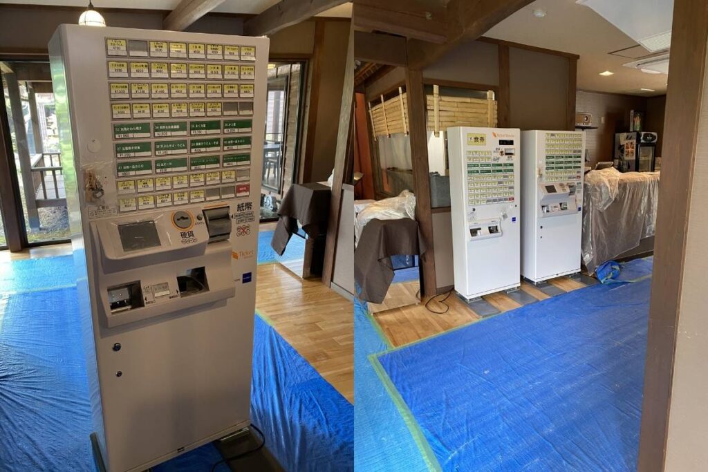廊下の床を養生しながら券売機を設置している作業風景