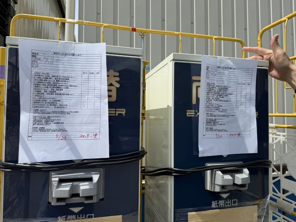 出荷前チェックリストを使用して両替機BX-108を点検している様子