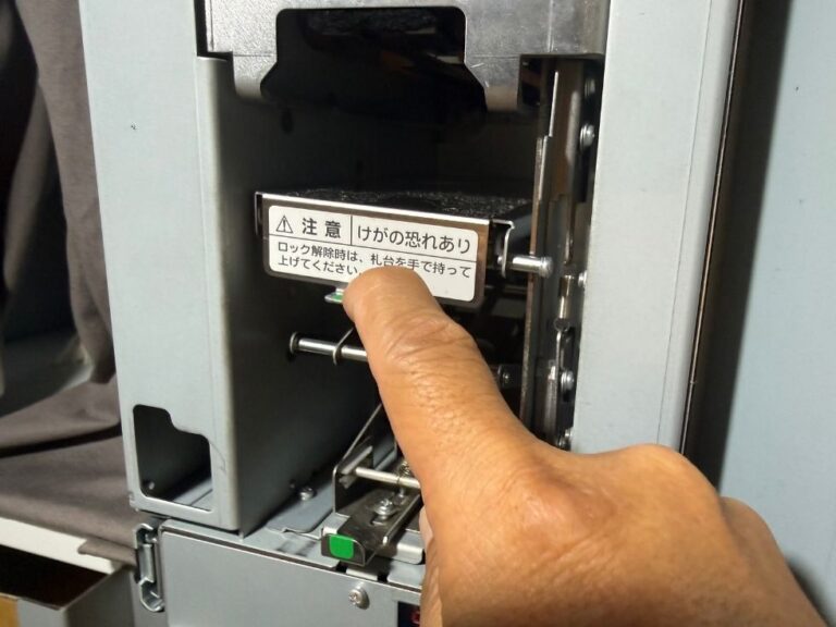 紙幣払い出しユニットNB-4W2の紙幣収納部を手で操作しているところ