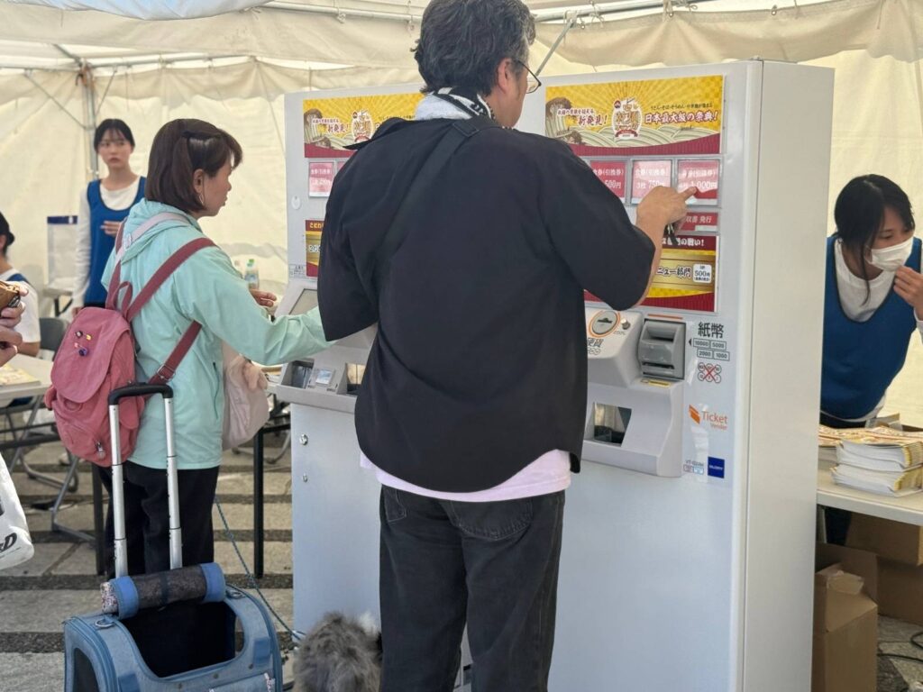 世田谷の乾麺グランプリで高額紙幣対応券売機VT-G20を使い、イベント参加者が食券を購入している様子